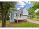 A light blue two-story home features a wooden deck, set amidst mature trees and greenery at 1139 Mainstreet Valley Dr, Stone Mountain, GA 30088