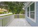 A light blue home's porch features a white railing, offering a view of the street and surrounding greenery at 1139 Mainstreet Valley Dr, Stone Mountain, GA 30088