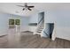 Bright living room with a ceiling fan, sliding door to deck, hardwood floors, and staircase access at 1139 Mainstreet Valley Dr, Stone Mountain, GA 30088