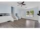 Bright living room features a ceiling fan, large window, and stylish gray wood-look flooring at 1139 Mainstreet Valley Dr, Stone Mountain, GA 30088