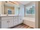 Bright bathroom features a double sink vanity, soaking tub, and a large window offering plenty of natural light at 275 Mountain Way, Covington, GA 30016
