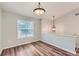 Well-lit dining area featuring modern light fixture, seamlessly connects to the upper level via a staircase at 275 Mountain Way, Covington, GA 30016
