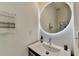 Modern powder bathroom with a round illuminated mirror, a floating vanity, and stylish fixtures at 3355 Olivia Ct, Cumming, GA 30041