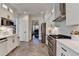 Bright kitchen with stainless steel appliances, white cabinets, and views into the next room at 3355 Olivia Ct, Cumming, GA 30041
