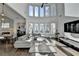 Bright living room boasts soaring ceilings, large windows, and modern decor, creating a welcoming atmosphere at 3355 Olivia Ct, Cumming, GA 30041