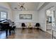Elegant living room featuring a grand piano, modern light fixture, and views into the kitchen at 3355 Olivia Ct, Cumming, GA 30041