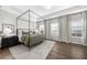 Bright bedroom features a modern canopy bed, wood floors, and neutral decor at 6370 Cortland Walk, Alpharetta, GA 30005