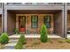 Inviting front porch with red door, brick facade, and elegant landscaping at 6370 Cortland Walk, Alpharetta, GA 30005