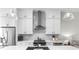 Close up of a modern kitchen featuring white cabinets, stainless steel appliances, and stylish lighting at 6370 Cortland Walk, Alpharetta, GA 30005