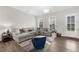 Cozy living room with a large sectional sofa, stylish rug, and ample natural light at 6370 Cortland Walk, Alpharetta, GA 30005