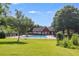 Community pool surrounded by a black fence and lush green grass, with a red brick pool house in the background at 7712 Autry Cir # 701, Douglasville, GA 30134