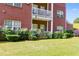 Apartment building featuring brick facade, white trim, and a grassy lawn with manicured landscaping at 7712 Autry Cir # 701, Douglasville, GA 30134