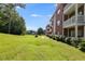 Apartment building with brick facade, multiple floors, and balconies overlooking green lawn and community pool in the background at 7712 Autry Cir # 701, Douglasville, GA 30134