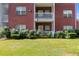 Brick apartment building with white balconies, complemented by a green lawn and flowering bushes at 7712 Autry Cir # 701, Douglasville, GA 30134