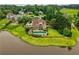 Aerial view of large house with pool overlooking pond with surrounding luxury houses and green lawns at 2675 Portabella Ln, Cumming, GA 30041