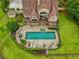 Aerial view of a home with a backyard pool, stone patio, outdoor kitchen, and lush landscaping at 2675 Portabella Ln, Cumming, GA 30041