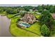 Breathtaking aerial view of a stunning home with an outdoor pool overlooking a serene lake surrounded by lush landscape at 2675 Portabella Ln, Cumming, GA 30041