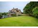 Exterior view of the house highlighting a large backyard with lush green grass, ideal for outdoor activities at 2675 Portabella Ln, Cumming, GA 30041