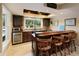 Basement bar with counter seating, cabinetry, and a bright window overlooking the outdoor area at 2675 Portabella Ln, Cumming, GA 30041