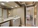 Well-lit bathroom featuring a spacious vanity, large mirror, and a glimpse into an adjacent bedroom at 2675 Portabella Ln, Cumming, GA 30041