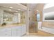 Luxurious Primary bathroom with a soaking tub, glass-enclosed shower, and dual vanities at 2675 Portabella Ln, Cumming, GA 30041