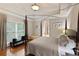 Comfortable bedroom with a four-poster bed, tray ceiling, and view to ensuite bathroom at 2675 Portabella Ln, Cumming, GA 30041
