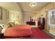 Spacious bedroom with neutral walls, a red bedspread, and framed art adding character at 2675 Portabella Ln, Cumming, GA 30041
