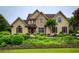 Attractive stucco home featuring stone accents, manicured landscaping, and elegant arched windows at 2675 Portabella Ln, Cumming, GA 30041