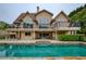 Spacious two-story home with balconies and a large outdoor pool offering luxurious lakeside living at 2675 Portabella Ln, Cumming, GA 30041
