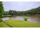 Scenic lake view with lush trees and grassy shoreline offering a peaceful and serene environment at 2675 Portabella Ln, Cumming, GA 30041