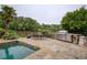 Outdoor patio area with stainless steel grill and dining table and in-ground pool with a scenic lake backdrop at 2675 Portabella Ln, Cumming, GA 30041