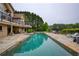 Stunning outdoor pool and patio with lake views; a perfect space for relaxation and entertaining guests at 2675 Portabella Ln, Cumming, GA 30041