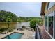Stunning outdoor space featuring a stone patio with a pool, lake view, and outdoor dining area at 2675 Portabella Ln, Cumming, GA 30041