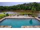 Inviting pool with a stone patio and outdoor furniture overlooks the lake and lush greenery at 2675 Portabella Ln, Cumming, GA 30041