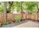 Backyard view featuring a wooden fence, mature trees, and a stone garden border at 151 Savannah Se St, Atlanta, GA 30316