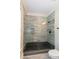 Contemporary shower featuring glass doors, gray tiled walls, and a dark shower base at 151 Savannah Se St, Atlanta, GA 30316