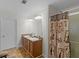 Well-lit bathroom with double sinks and a shower with patterned curtain at 3430 Grand Manor Trl, Snellville, GA 30039