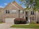 Charming two-story home features a grey brick exterior, well-manicured lawn, and a two-car garage at 3430 Grand Manor Trl, Snellville, GA 30039