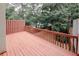 Wooden back deck with a view of mature trees and fenced backyard at 3697 E Bay St, Duluth, GA 30096