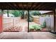 A fenced backyard with wooden beam roof, featuring garden beds and greenery, perfect for outdoor enjoyment at 3697 E Bay St, Duluth, GA 30096