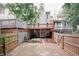 Back of townhome featuring fenced yard with garden beds, porch and decks at 3697 E Bay St, Duluth, GA 30096