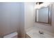 Cozy powder room with a vanity, faucet, framed mirror, and a toilet, illuminated by sconce lighting at 3697 E Bay St, Duluth, GA 30096