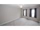 Neutral bedroom features soft carpeting, two windows with curtains, and ceiling fan at 3697 E Bay St, Duluth, GA 30096