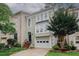 Lovely townhome with a two-car garage, a well-manicured lawn, and a charming entrance with a garden at 3697 E Bay St, Duluth, GA 30096