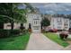 Inviting townhome showcasing a well-maintained lawn, a driveway, and charming curb appeal with lush greenery at 3697 E Bay St, Duluth, GA 30096
