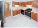 Contemporary kitchen with stainless steel appliances, neutral countertops, and wood cabinetry, providing a stylish cooking area at 3697 E Bay St, Duluth, GA 30096