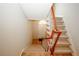 Interior view of a staircase featuring neutral carpeting and wood banisters, with a door at the landing at 3697 E Bay St, Duluth, GA 30096