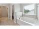 Inviting bathroom showcasing a bright window next to a soaking tub at 4090 Danbury Farms Dr, Cumming, GA 30040