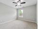 Neutral bedroom features a ceiling fan and a window providing natural light at 4090 Danbury Farms Dr, Cumming, GA 30040