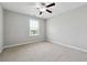 This bedroom features neutral walls, a ceiling fan, and a window for natural light at 4090 Danbury Farms Dr, Cumming, GA 30040